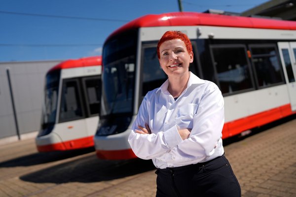 DVG-Straßenbahnfahrerin vor Straßenbahnen auf dem Betriebshof Grunewald