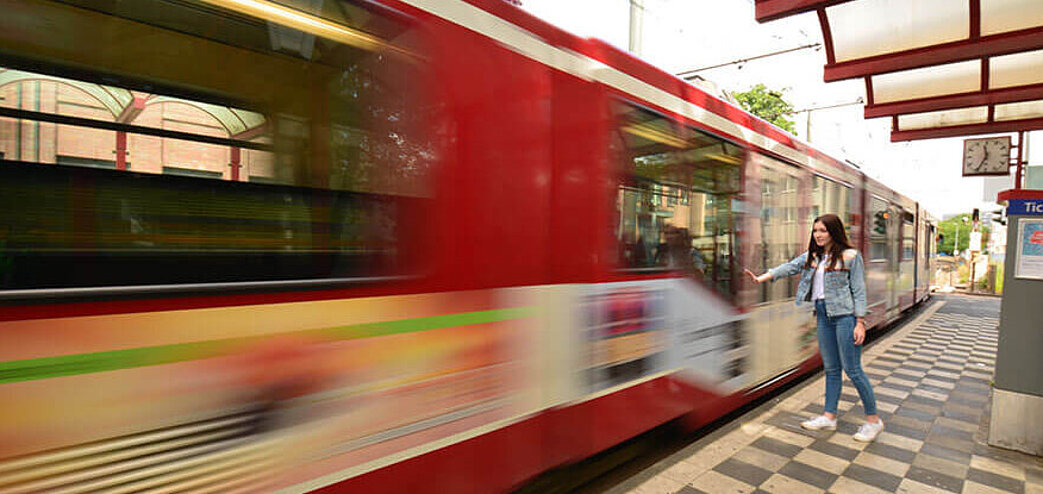 Foto von einer abfahrenden Straßenbahn an einer Haltestelle